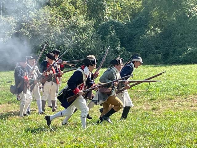 Image shows a reenactment of revolutionary war era soldiers